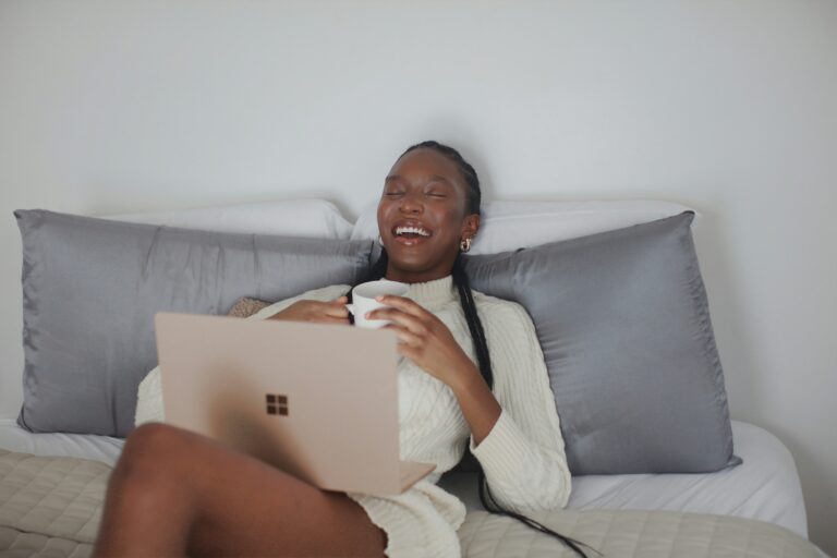 Mulher sorrindo enquanto usa um notebook sem fio, simbolizando a praticidade e a alegria da conexão Wi-Fi no cotidiano. Uma imagem que representa a facilidade de acesso à internet.